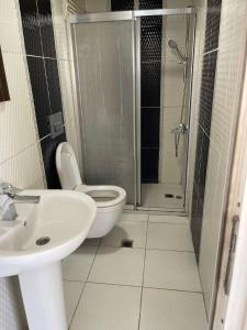 La salle de bains est pourvue de toilettes, d'un lavabo et d'une douche. dans l'établissement Simge suitotel, à Istanbul
