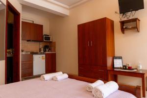 um quarto com 2 camas e uma pequena cozinha em Apartment’s Vasileiou Suite 1 em Preveza