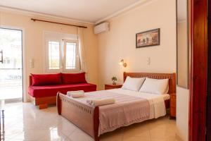 a bedroom with a bed and a red couch at Apartment’s Vasileiou Suite 1 in Preveza
