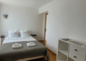 a bedroom with a bed with two towels on it at Le jardin des oliviers in Apt