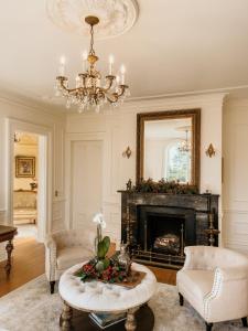 a living room with a fireplace and a chandelier at Mayhurst Estate in Orange