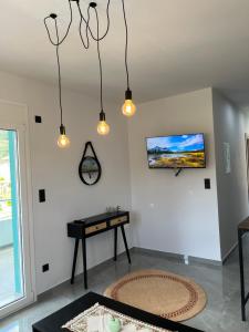 ein Wohnzimmer mit von der Decke hängenden Lampen in der Unterkunft faskomilo house 1 in Faskomiliá