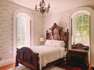 1 dormitorio con 1 cama grande y 2 ventanas en Mayhurst Estate, en Orange