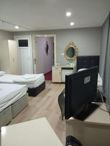 Pokój z 2 łóżkami i biurkiem z komputerem w obiekcie Simge suitotel w Stambule