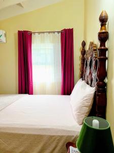 um quarto com uma cama com uma cabeceira em madeira e cortinas vermelhas em L&V Paradise Vacation Home with Pool and Gym em The Rock
