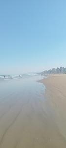 a beach with people walking on the sand at Edifício Cannes AP 16A in Praia Grande