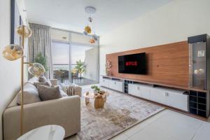 a living room with a couch and a tv at GuestReady - Viver com glamour em Palm Jumeirah in Dubai
