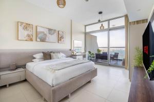 um quarto com uma cama grande e uma varanda em GuestReady - Viver com glamour em Palm Jumeirah em Dubai