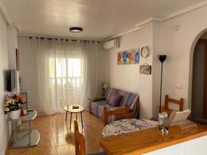 - un salon avec un canapé et une table dans l'établissement VACATION NEAR THE SEA. (POOL-SHOPS-RESTAURANTS), à Torrevieja