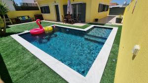 a swimming pool with a pink swan and a toy at Holidays Home Comporta in Comporta