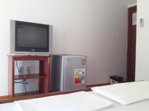 a room with a television and a small refrigerator at Hiep Hoa Resort in Mui Ne