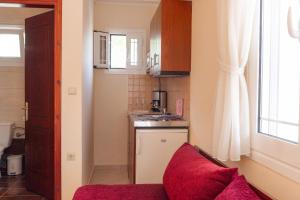 uma pequena cozinha com um sofá vermelho num quarto em Apartments Vasileiou Suite 2 em Preveza