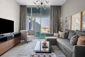 a living room with a couch and a tv at GuestReady - Magnífica casa em Aliyah Azizi in Dubai