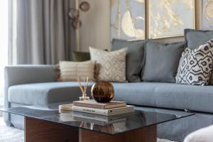 a living room with a blue couch and a coffee table at GuestReady - Magnífica casa em Aliyah Azizi in Dubai