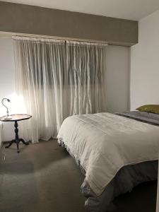 a bedroom with a bed and a table with a lamp at Depto 51 in La Plata