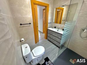 un baño con inodoro y lavabo en Apartamaento Asis A, en Albuñán 11 fotos más