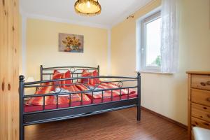 a bedroom with a bed with red sheets and a window at Günther - Ferienwohnungen Zinnowitz in Zinnowitz
