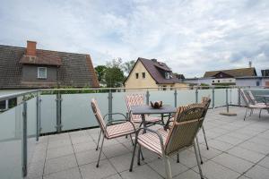a patio with a table and chairs on a balcony at Günther - Ferienwohnungen Zinnowitz in Zinnowitz