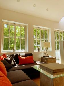 a living room with a couch and some windows at Comfortable living in Prestasen Park - only 500m to Sandefjord centre and the harbour, in Sandefjord +16 photos