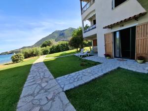 a backyard of a house with a grass yard at Lefkada Eli's amazing beach house in Nikiana