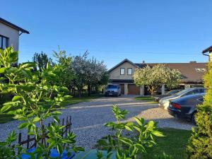 a driveway in front of a house with cars parked at Apartamentai Rimkuose in Klaipėda +7 photos