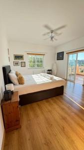 a bedroom with a large bed with a ceiling fan at Luxury holiday escape in the countryside tavira in Tavira