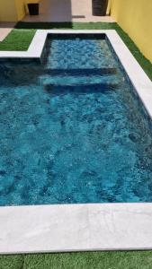 a swimming pool with blue water in a yard at Holidays Home Comporta in Comporta