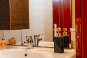um lavatório de casa de banho com duas garrafas de sabão em Apartments Vasileiou Suite 3 em Preveza