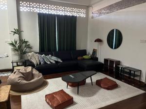 ein Wohnzimmer mit einem Sofa und einem Tisch in der Unterkunft La Wood Homestay near Kuala Besut Jetty in Kampung Kuala Besut