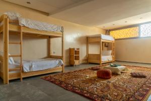 a bedroom with two bunk beds and a rug at Tayyurt host in Agadir