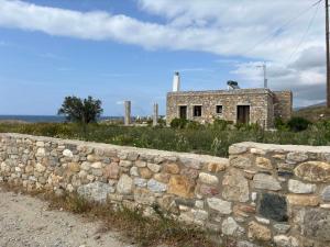 an old stone wall in front of a building at Mitato's Horizon in Akrotiri