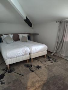 - un lit blanc installé dans une chambre dans l'établissement Logis Hôtel Les Pages, à Lunéville