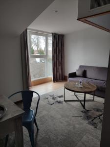 uma sala de estar com um sofá e uma mesa em Logis Hôtel Les Pages em Lunéville