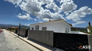 una casa blanca con una valla delante en Apartamaento Asis A, en Albuñán