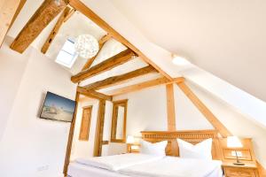 2 bedden in een zolderslaapkamer met houten balken bij Aparthotel an Sankt Marien in Stralsund