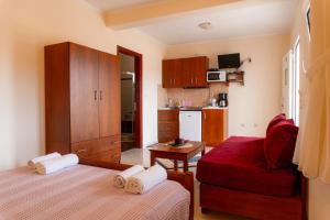 a small room with a bed and a red chair at Apartments Vasileiou Suite 4 in Preveza