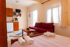 a living room with a bed and a red couch at Apartments Vasileiou Suite 4 in Preveza