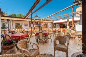 a restaurant with tables and chairs with red table cloth at Oltre il Mare Trabia in Trabia