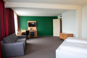 ein Hotelzimmer mit einem Bett, einem Stuhl und einem Schreibtisch in der Unterkunft SleepBEEONE AIRPORTHOTEL FRANKFURT MÖRFELDEN in Mörfelden-Walldorf