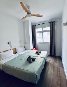 a bedroom with two beds and a ceiling fan at Rosamar Playa de Las Canteras in Las Palmas de Gran Canaria
