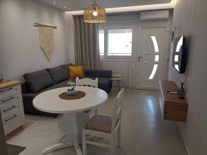 a living room with a table and a couch at Dimitros Apartment II in Neos Marmaras