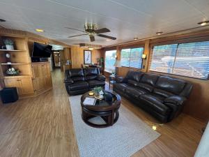 a living room with leather couches and a coffee table at Palmetto Paradise Houseboat in Seneca