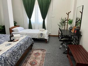 um quarto de hotel com duas camas e uma secretária e uma janela em La Wood Homestay near Kuala Besut Jetty em Kampung Kuala Besut