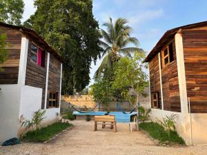 a yard with two buildings and a table and a bench at Cabana Bacalar in Bacalar