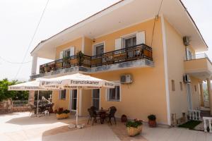 a building with a balcony and an umbrella at Apartment’s Vasileiou Suite 1 in Preveza