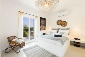 Villa Paralía - Best seaside في Agia Irini Paros: غرفة نوم بيضاء بها سرير ونافذة
