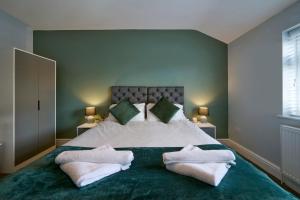 una camera da letto con un grande letto con due asciugamani bianchi di Luxury - Close To Centre - Free Parking - 4 Beds a Manchester