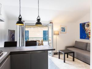 a kitchen and living room with a couch and a table at Elegante a due passi dal mare in Alassio