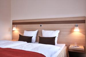 Postel nebo postele na pokoji v ubytování Montra Hotel Sabro Kro