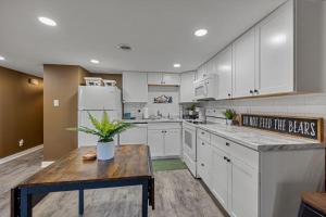 a kitchen with white cabinets and a wooden table at Bearadise Mountain Getaway by Eden Crest in Sevierville +37 photos
